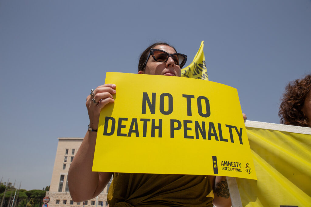 Activist holding placard No to Death Penalty.