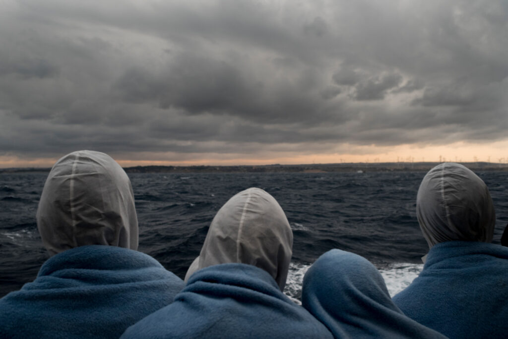 Migrants looking to Italy after being rescued in the SAR